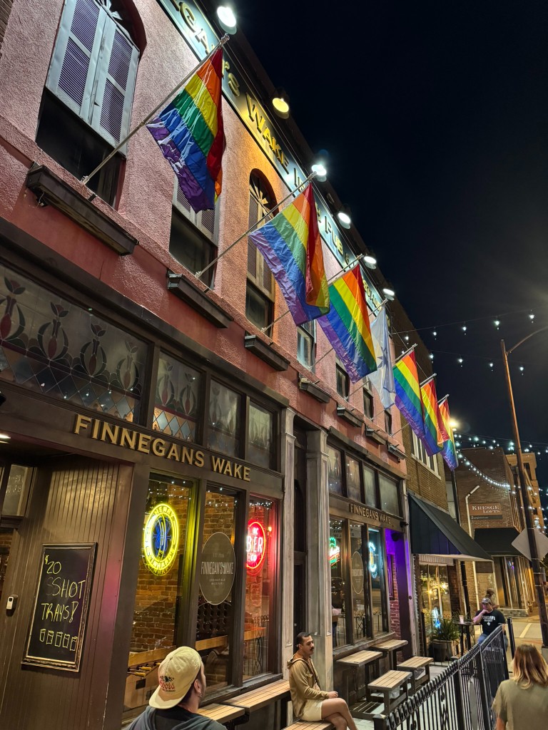 Finnegan's Wake storefront at night on South Avenue, pride flags along the sidewalk