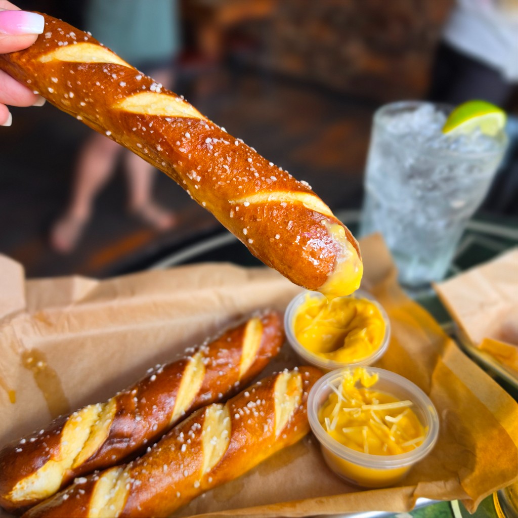 Pretzel sticks dipping in cheese