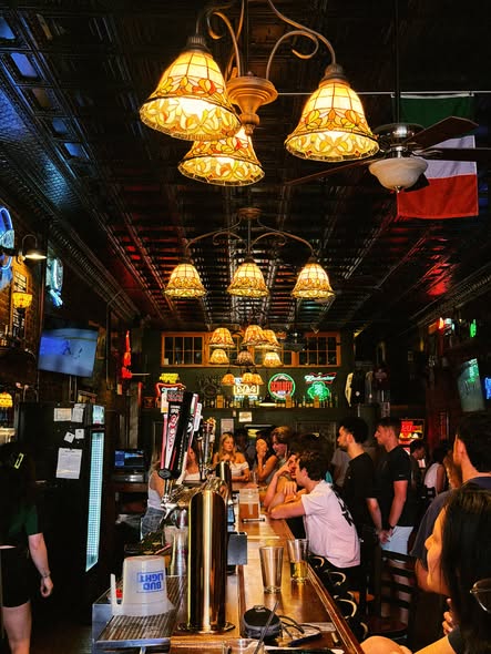 Patrons gathered at the bar under Finnegan's Wake's stained-glass lamps